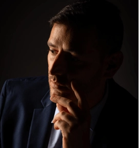 O Colapso Cognitivo sob Pressão: A Neurobiologia do Travamento Não há nada de misterioso ou "emocional" no travamento do idioma durante reuniões cruciais. Trata-se de neurobiologia estrita.
Em cenários de alta exigência social — como sabatinas de conselho, comitês de investimentos ou negociações hostis —, a percepção de risco ativa o eixo HPA e deflagra o sequestro da amígdala. Esse mecanismo neurobiológico drena o fluxo sanguíneo do córtex pré-frontal — a região responsável pelo raciocínio abstrato, pela recuperação lexical e pela articulação lógica no segundo idioma.
O resultado é a paralisia momentânea da memória de trabalho: o profissional sênior tropeça em termos triviais exatamente quando precisa demonstrar maior autoridade. Conquistar a alta performance cognitiva em inglês exige o treino da regulação autonômica sob pressão simulada. É a neuro-oratória que preserva a clareza e a compostura executiva quando não há margem para erro.